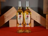 two bottles of wine sitting on a table next to each other