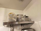 a metal shelf with pots and pans on top of it