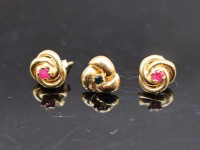 trois paires de boucles d'oreilles en or et rubis sur un fond noir