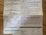 un ticket de caisse posé sur une table, à côté d'un téléphone portable