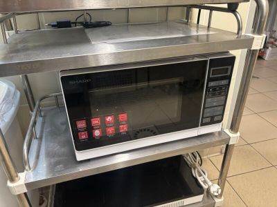 a microwave that is sitting on a shelf in a kitchen