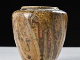 a brown vase sitting on a white table