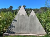 a concrete sculpture of a mountain with trees in the background