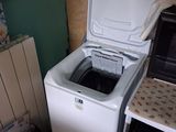 an image of a small kitchen with a washing machine and microwave
