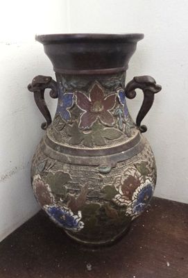 un vase posé sur une étagère près d'un mur
