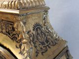 a gold clock with a bird on top of it