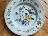 a plate with a flower design on it on a wooden floor