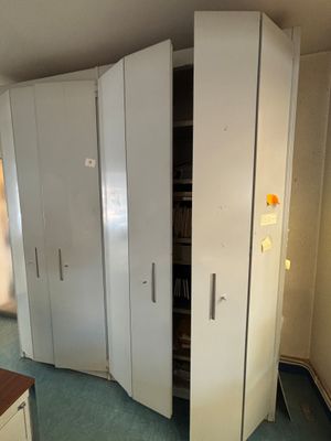 un placard dans un coin d'une pièce, dont la porte est ouverte