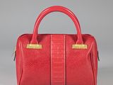 un sac à main en cuir rouge avec des anses dorées