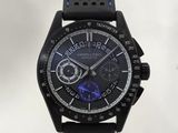 La montre est noire et bleue, avec une trotteuse bleue.