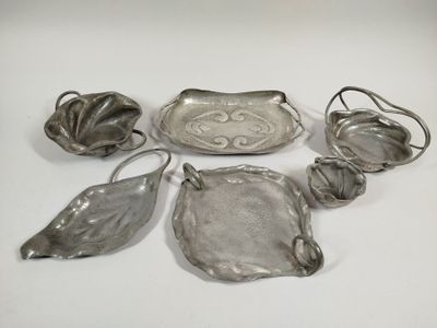 six silver plated dishes and spoons on a white surface