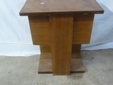 une petite table en bois sur laquelle se trouve un vase