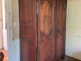 a large wooden armoire in the middle of a room