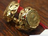 a gold bell on a red string with a tag