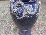 a blue vase with a dragon on it in the grass