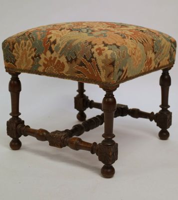 a small foot stool with a floral upholstered seat