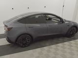the tesla model y is parked in the garage with its door open
