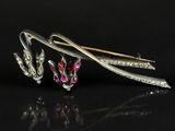 un gros plan sur une paire d'épingles à cheveux en argent ornées de pierres roses