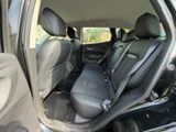 the back seats of a car with the door open and the driver ' s seat folded down