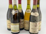 several bottles of wine are lined up on a white surface