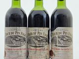trois bouteilles de vin rouge posées sur une table blanche