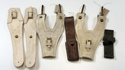 plusieurs morceaux de cuir sont suspendus à une ficelle accrochée au mur