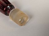 a glass bottle with a liquid inside of it on a white surface