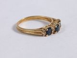 a close up of a gold ring with three sapphire stones