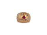a close up of a gold ring with a ruby stone