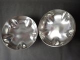 pair of silver plated dishes on a black surface