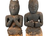 deux statues représentant un homme et une femme assis sur une souche d'arbre