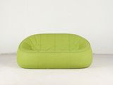 un pouf vert citron devant un mur blanc