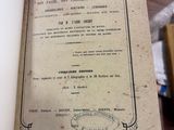 quelqu'un tient un livre ouvert sur une table où se trouvent plusieurs autres livres