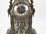 une horloge posée sur un support sur une surface blanche
