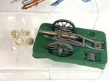 a small model of a cannon on display in a display case