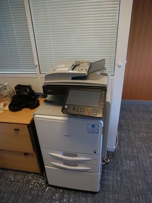 une imprimante posée sur un bureau, à côté d'un téléphone