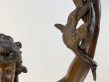 bronze statue of a woman holding a bird in her hand