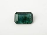 a green emerald stone on a white surface
