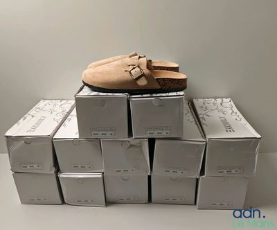 une pile de cartons sur laquelle est posée une paire de chaussures