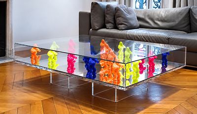 une table basse en verre sur laquelle sont disposés de nombreux animaux en plastique colorés