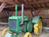 un tracteur vert qui se trouve dans une grange