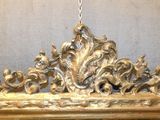 a mirror with a gold frame hanging on a wall
