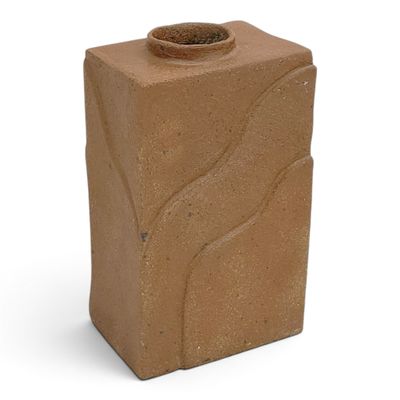 a brown vase that is sitting on a white surface
