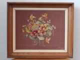 tableau représentant un bouquet de fleurs dans un cadre en bois posé sur une table