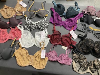 de nombreux soutiens-gorge posés sur une table, avec leurs étiquettes
