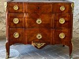 a chest of drawers that has gold decorations on it