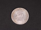 gros plan d'une pièce de monnaie en argent sur une surface noire