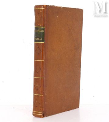 an old book sitting on top of a table next to a white wall