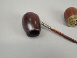 a wooden pipe and a wooden pipe holder on a table