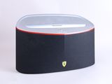 un gros plan d'une enceinte noire et rouge posée sur une surface blanche